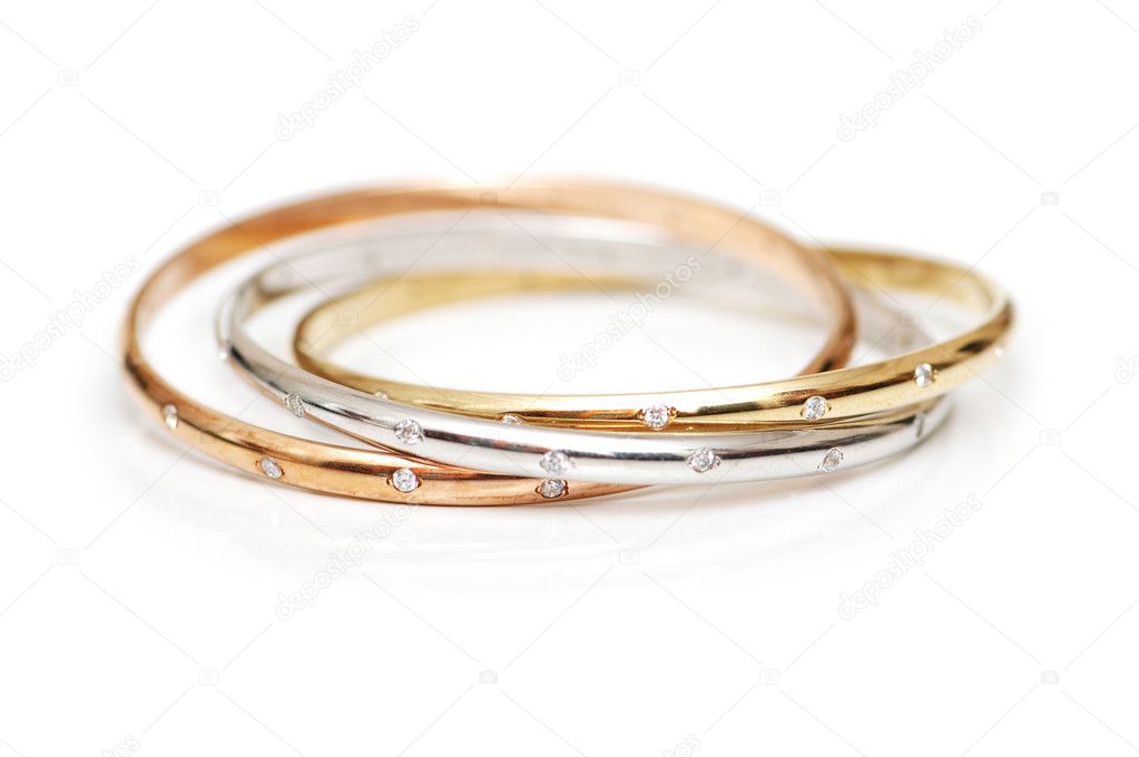Three gold bracelets isolated on the white