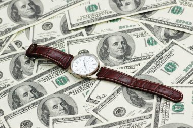 Hand watch over the hundred dollar bank notes clipart