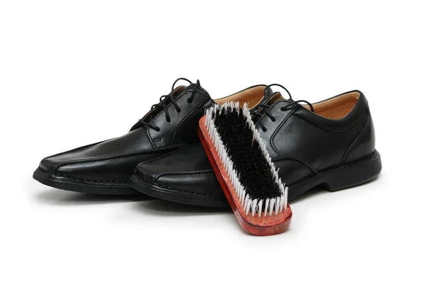 Black leather shoes and brush isolated on white — Stock Photo, Image