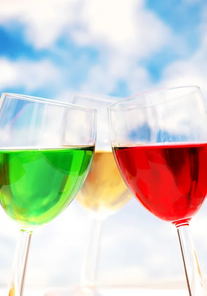 Cocktails in verschiedenen Farben gegen blauen Himmel — Stockfoto