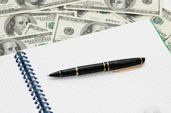 Business concept - pen and notebook over dollars — Stock Photo, Image