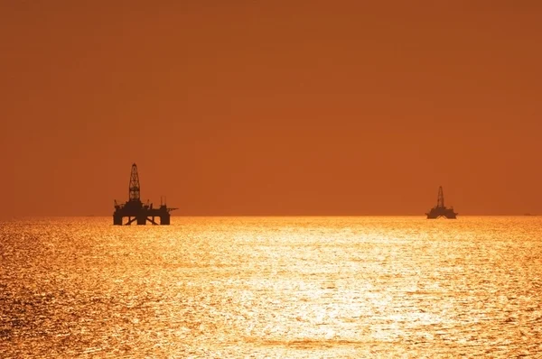 Δύο υπεράκτιες εξέδρες άντλησης πετρελαίου κατά τη διάρκεια του ηλιοβασιλέματος στην Κασπία se — Φωτογραφία Αρχείου