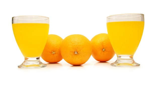 Τρία πορτοκάλια και το χυμό πορτοκαλιού που απομονώνονται σε λευκό — Φωτογραφία Αρχείου