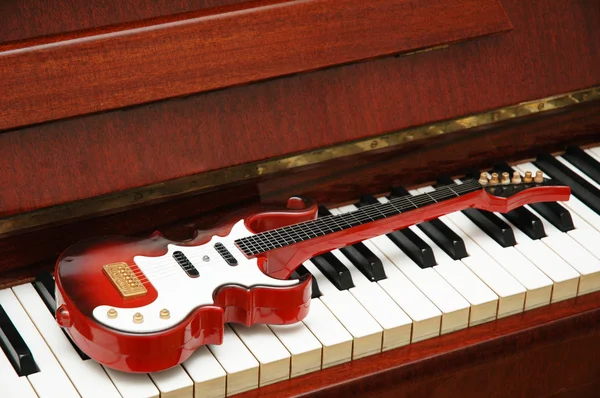 Concetto musicale - Chitarra rock sui tasti del pianoforte — Foto Stock