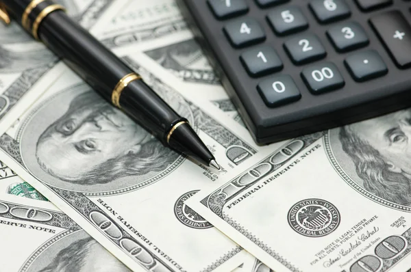 Калькулятор и ручка более 100 долларов банкноты — стоковое фото