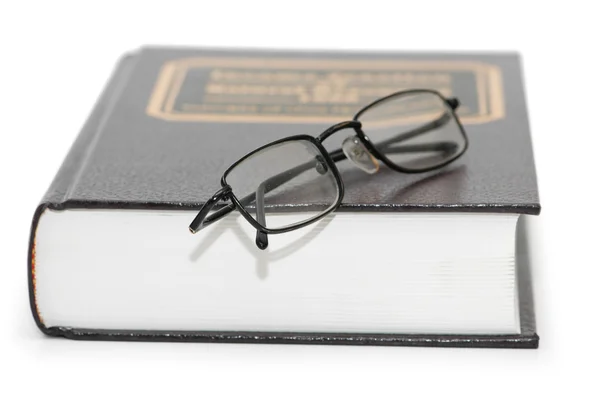 Leesbrillen over het boek geïsoleerd op wit — Stockfoto