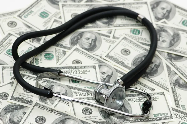 Tıp kavramı - steteskop dolar faturaları üzerinden — Stok fotoğraf