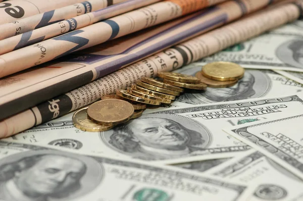 Jornais de negócios, moedas e notas em dólares — Fotografia de Stock