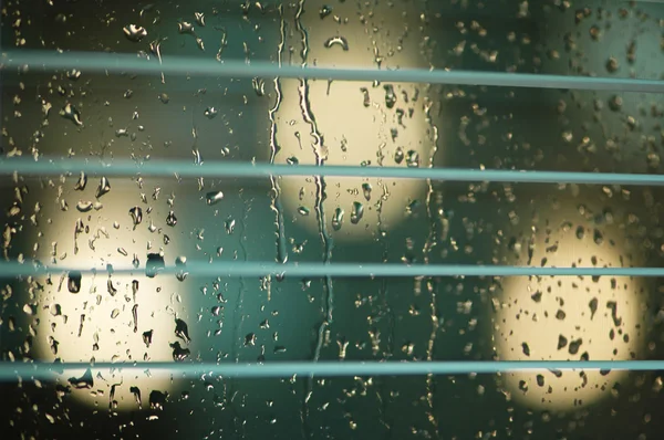 Water drops on the glass and blinds with shallow DOF — Stock Photo, Image