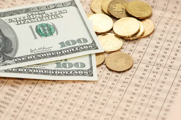 Bankbiljetten en muntstukken van honderd dollar boven de financiële cijfers — Stockfoto