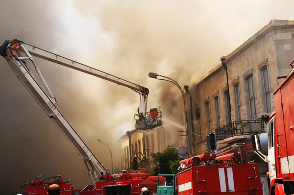 Firefighters at the fire in the citycenter — Stock Photo, Image