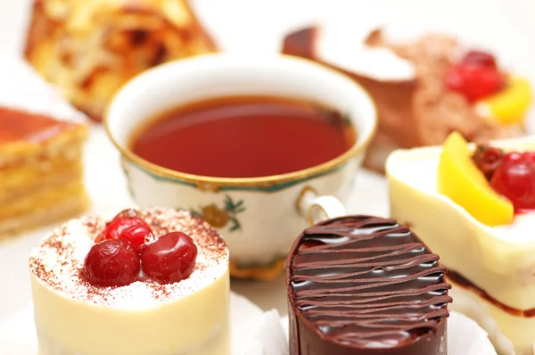 Выбор сладких тортов и чая на столе — стоковое фото