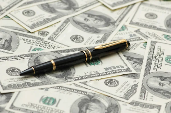 Bolígrafo negro sobre los billetes de banco en dólares — Foto de Stock