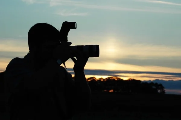 Silhouet van een fotograaf tijdens de zonsondergang — Stockfoto