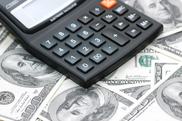 Calculadora de contabilidade sobre as notas de banco de cem dólares — Fotografia de Stock