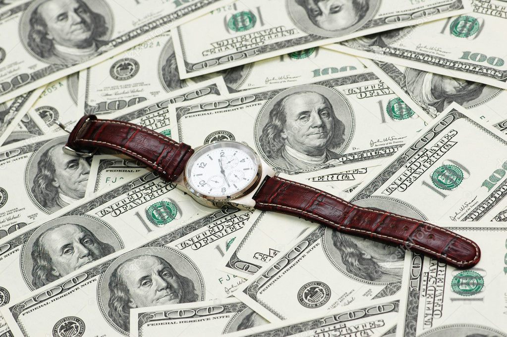 Hand watch over the hundred dollar bank notes