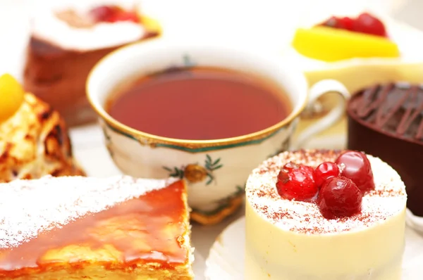 Söt tårta med bär och en kopp te — Stockfoto