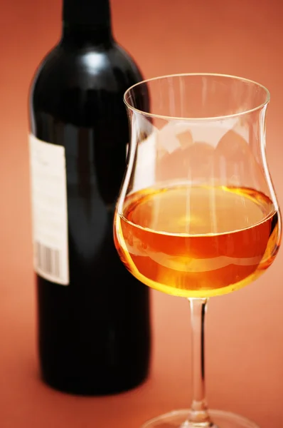 Sklenice na víno a láhev na biege pozadí — Stock fotografie