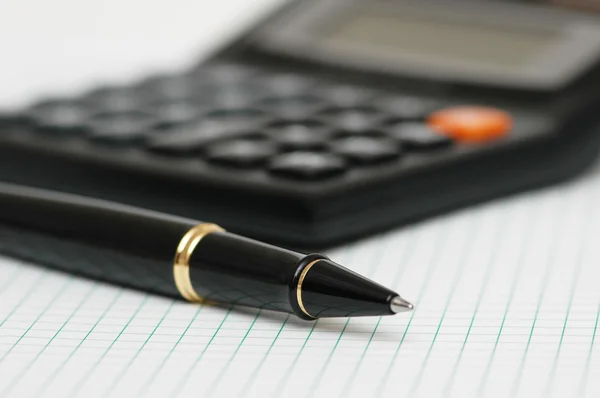 Pen and calculator with shallow depth of field — Stock Photo, Image