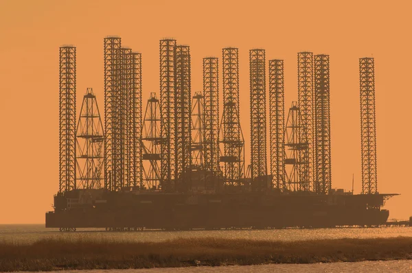 Нефтяная вышка на мелководье на закате — стоковое фото