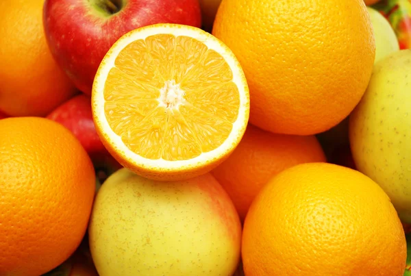 Яблоки и апельсин на стенде — стоковое фото