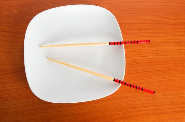 木製のテーブルの上の箸を使ってプレート — ストック写真