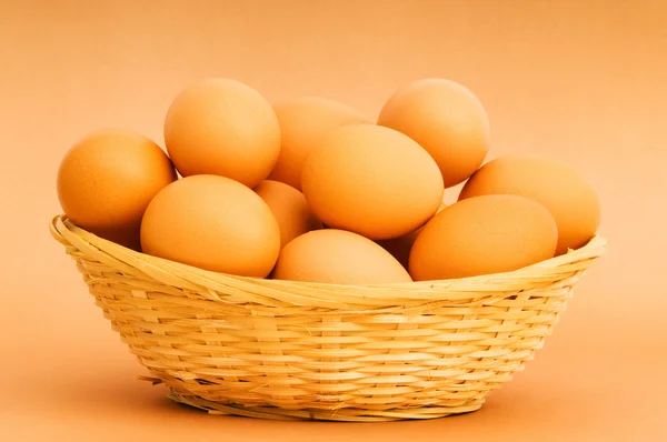 Korb mit Eiern auf dem bunten Hintergrund — Stockfoto