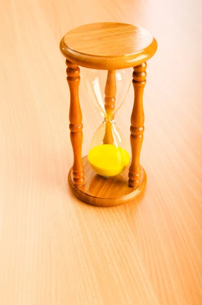 Time concept with hourglass on wooden background — Stock Photo, Image
