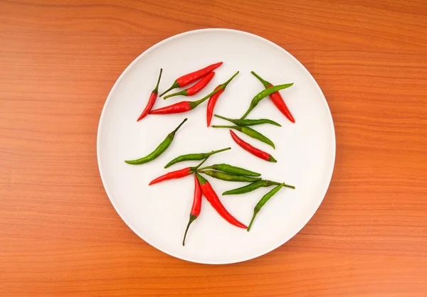 Varm paprika i plattan på träbord — Stockfoto