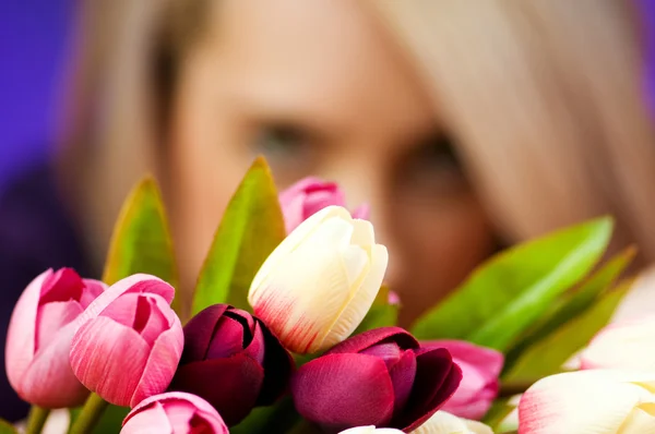 Menina com tulipas contra fundo colorido — Fotografia de Stock