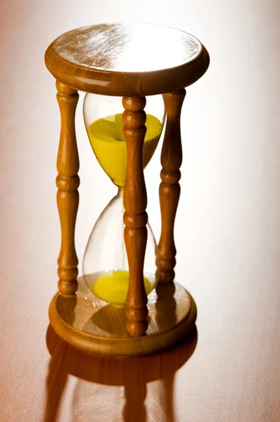 Концепція часу з пісочним годинником на дерев'яному фоні — стокове фото