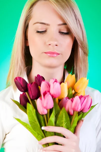 Młoda dziewczyna z tulipanów na kolorowym tle — Zdjęcie stockowe