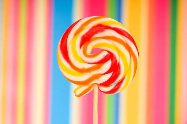Kleurrijke lollipop tegen de kleurrijke achtergrond — Stockfoto