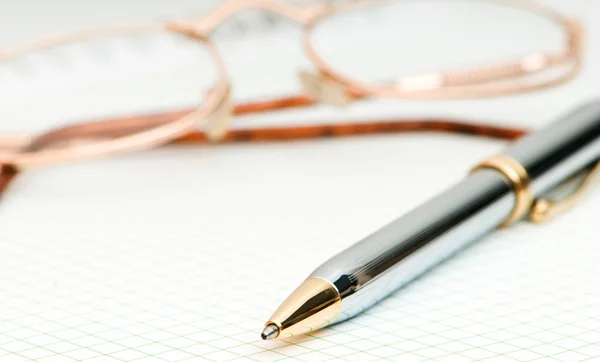 Pen en oog glazen op de pagina — Stockfoto