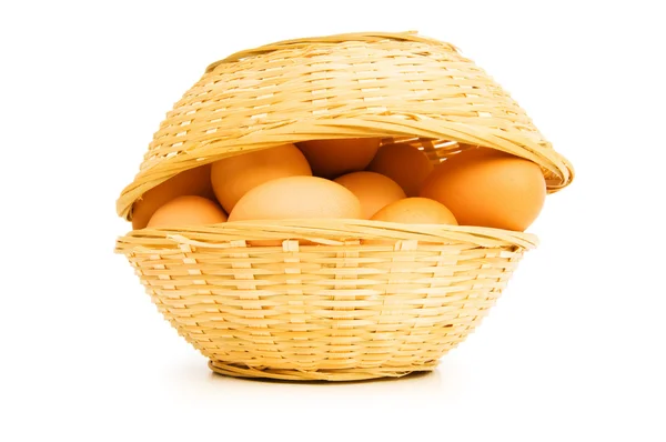 Bruna ägg i korgen på vitt — Stockfoto