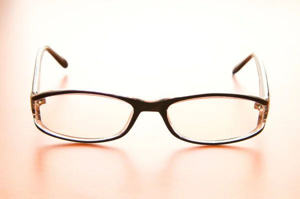 Brýle na čtení na dřevěný stůl — Stock fotografie