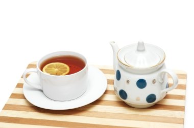 Cup of tea with lemon and pot isolated on the white clipart