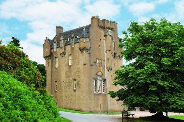 Scottish castle between the trees in summer day clipart