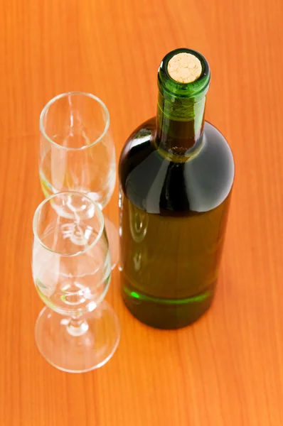 Láhev vína na dřevěný stůl — Stock fotografie