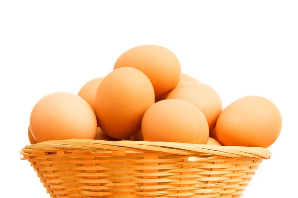 Hnědá vejce v košíku na bílém — Stock fotografie