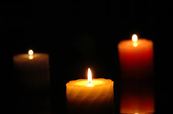 Три свечи в темноте - сфокусируйтесь на средней — стоковое фото