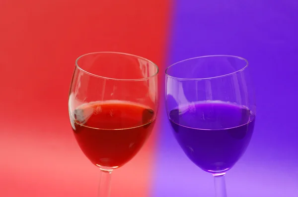 Dwa kieliszki do wina na czerwonym tle — Zdjęcie stockowe