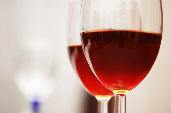 Dois copos de vinho contra o fundo vermelho — Fotografia de Stock