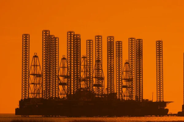 Offshore olja rigg på grunt vatten under solnedgången — Stockfoto