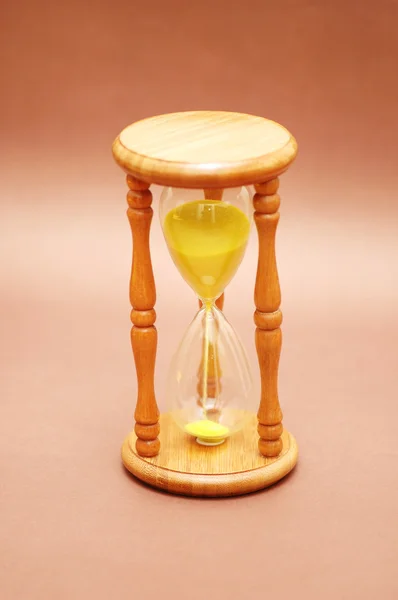 Reloj de arena de madera contra fondo marrón — Foto de Stock