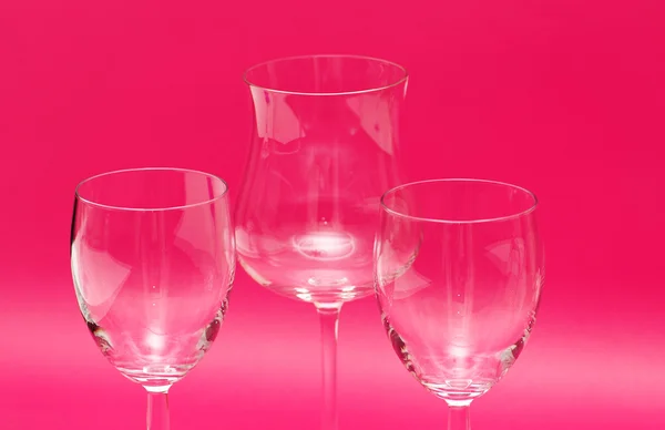 Três copos de vinho contra o fundo vermelho — Fotografia de Stock