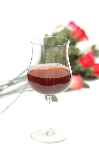 Glas wijn en bloemen geïsoleerd op wit — Stockfoto