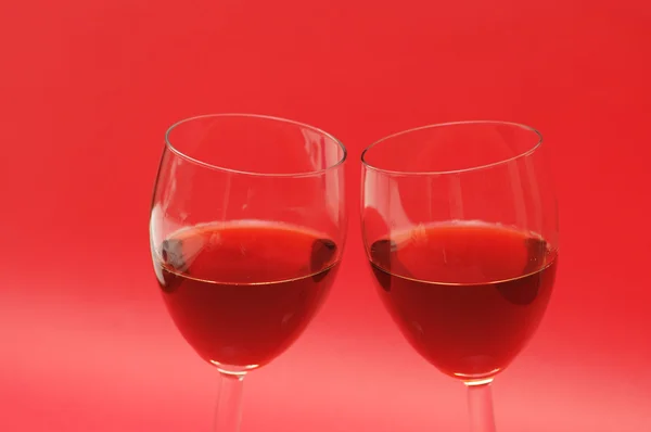Zwei Weingläser vor rotem Hintergrund — Stockfoto