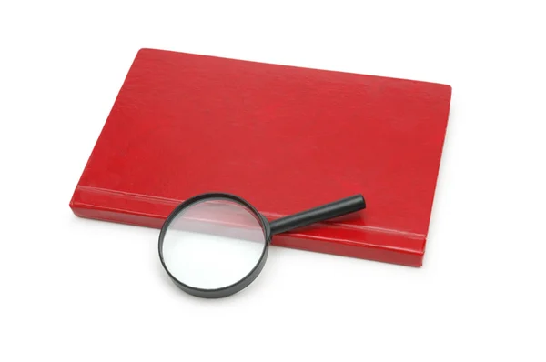 Lupa sobre o livro vermelho isolado em branco — Fotografia de Stock