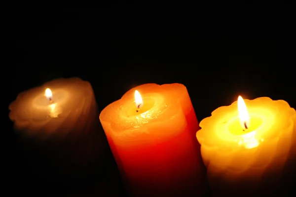 Три свічки в темряві фокус на середині — стокове фото